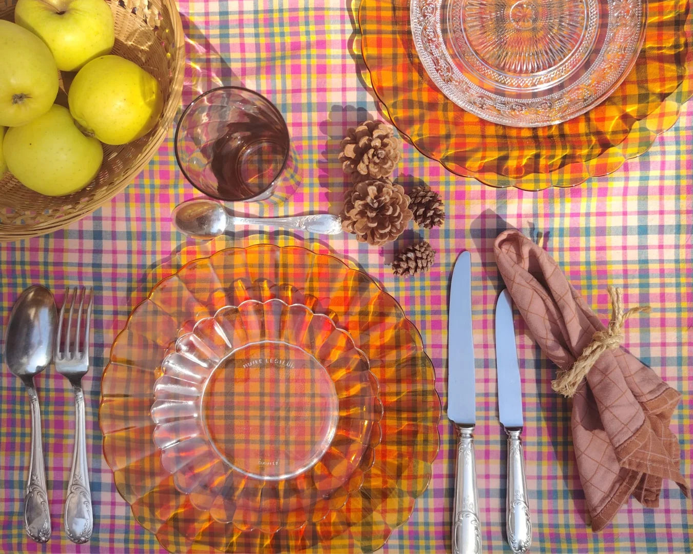 Assiettes et couverts sur une nappe rose