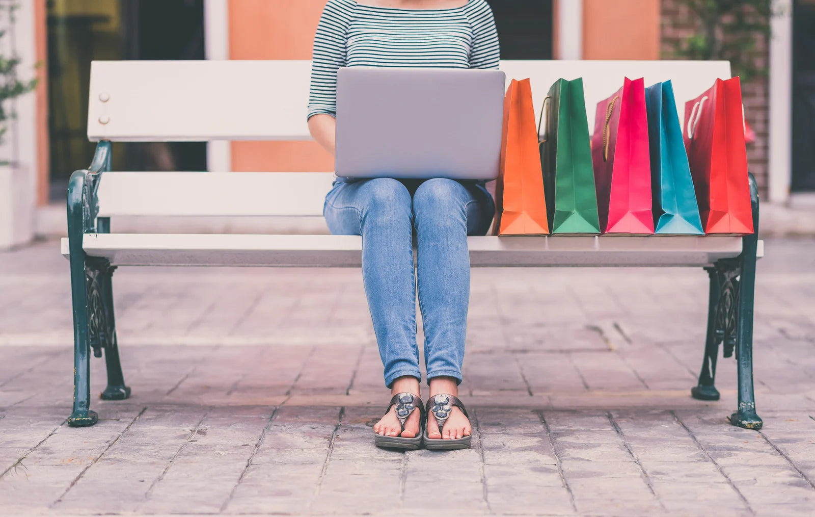 Une femme assise sur un banc qui fait ses achats